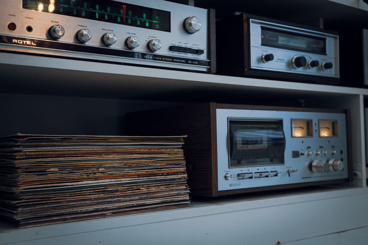 Vintage hi-fi separates on shelves beside a pile of records